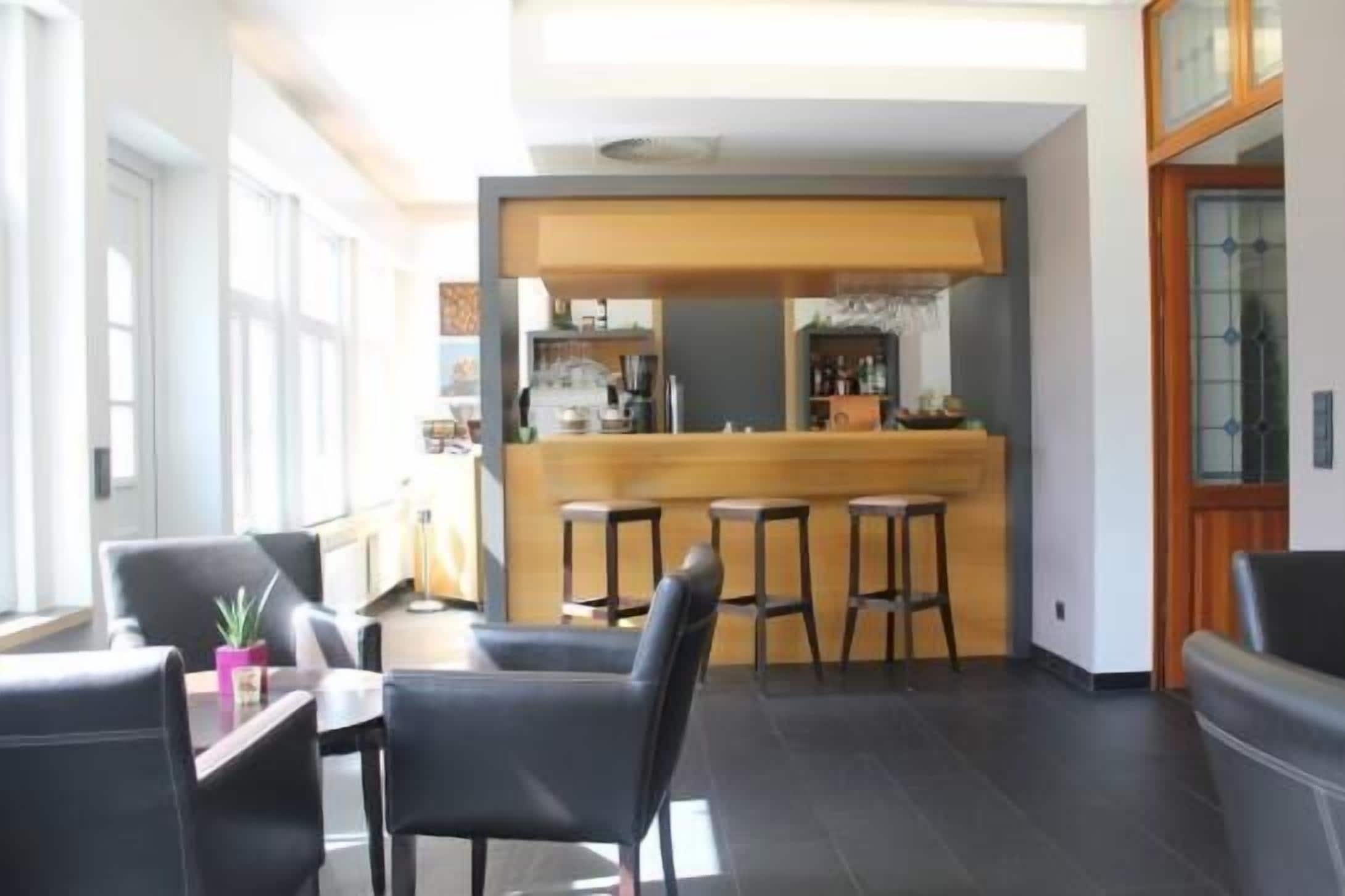 Un interior moderno con una zona de bar, asientos y vistas al exterior.