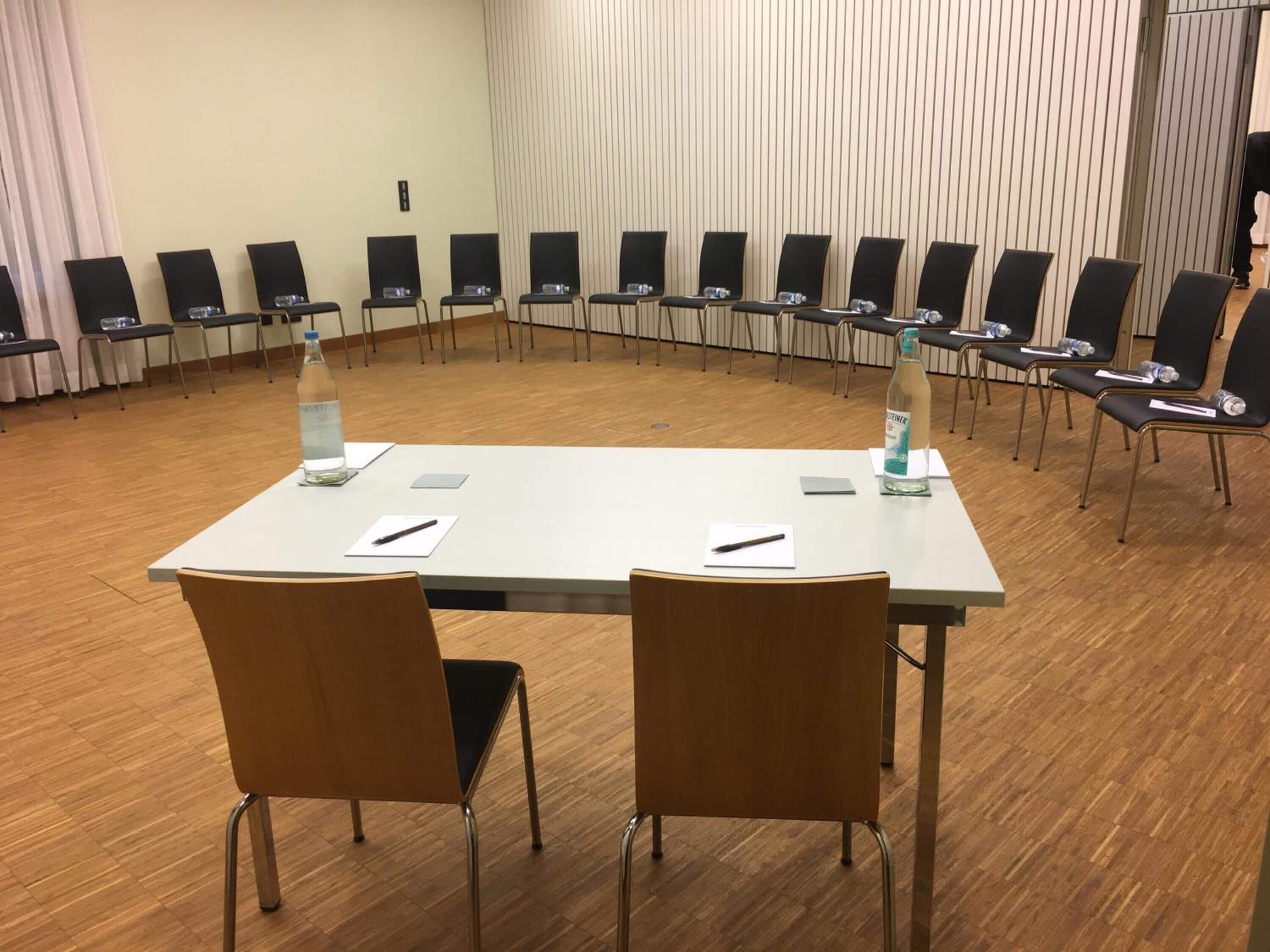 A conference room with a long table, chairs, and water bottles.
