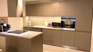 A modern kitchen with a central island, a built-in microwave, and a coffee machine. - Rezidence Muzeum (Prague)