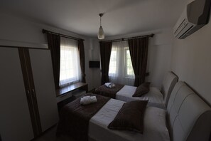 Una habitación de hotel con dos camas, un escritorio y un televisor.