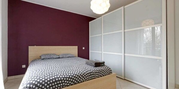 Une chambre à coucher avec un lit, une armoire et une fenêtre.
