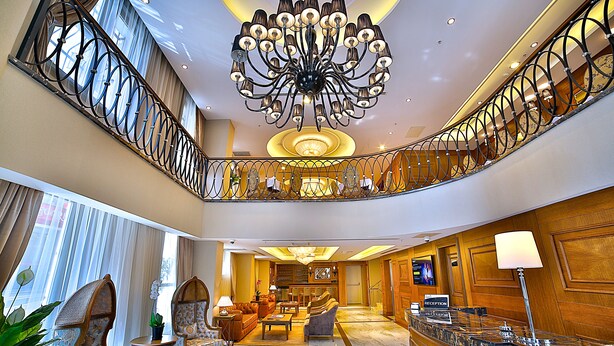 A spacious lobby with a grand chandelier, a reception desk, and a seating area with comfortable chairs. - Adelmar Hotel İstanbul Sisli (Istanbul)