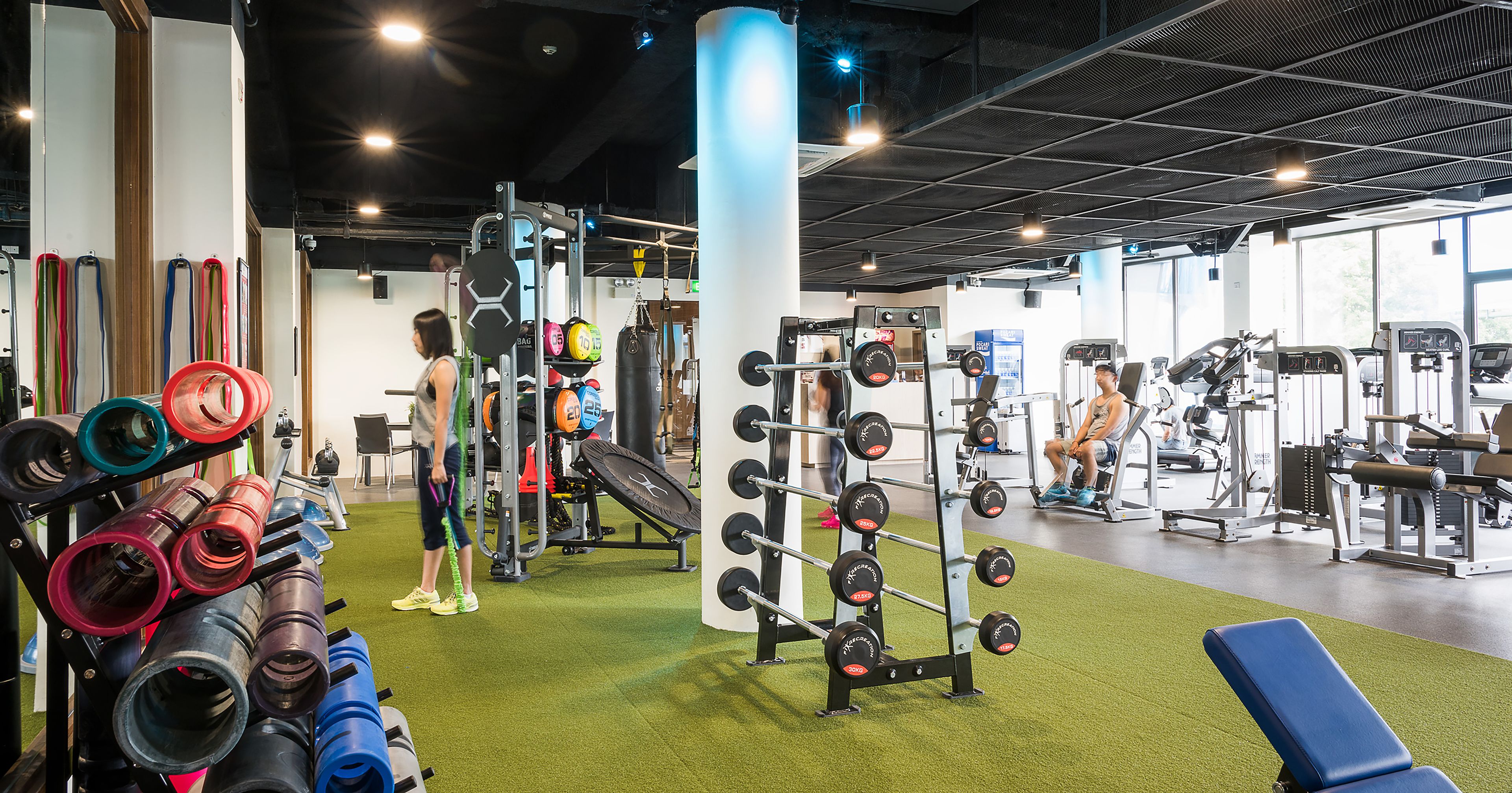 A gym with various exercise equipment, including weight racks and cardio machines.