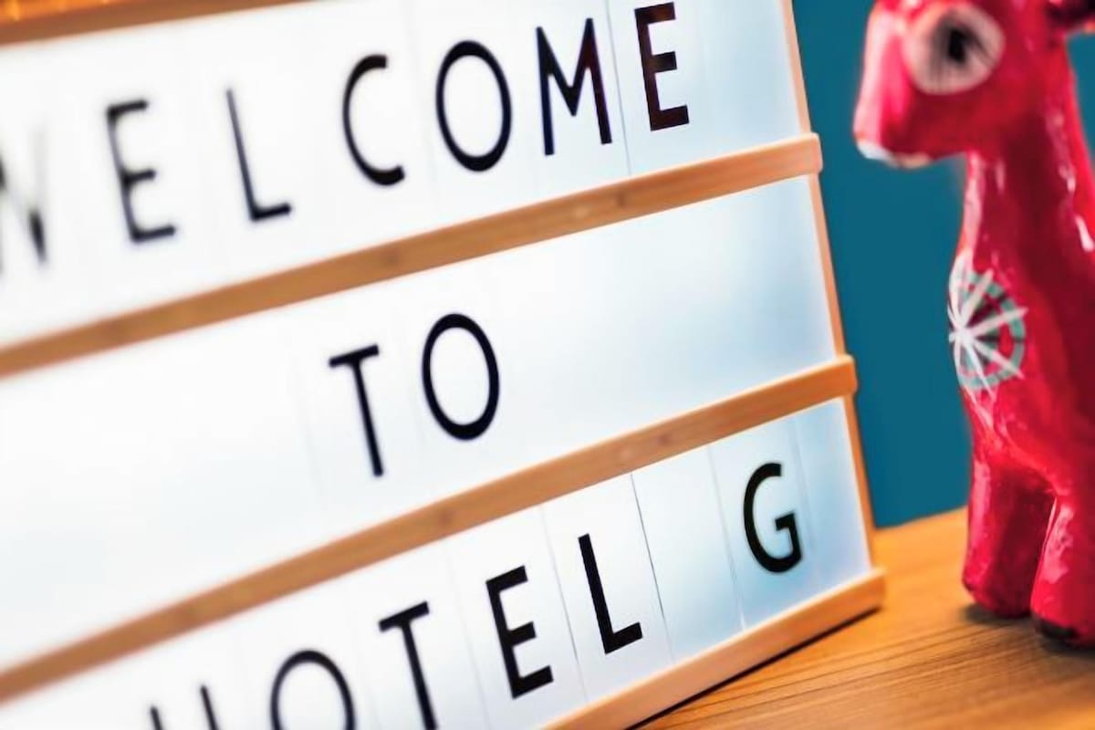A close-up of a lightbox with the words 'WELCOME TO HOTEL' and a red decorative object to the right.