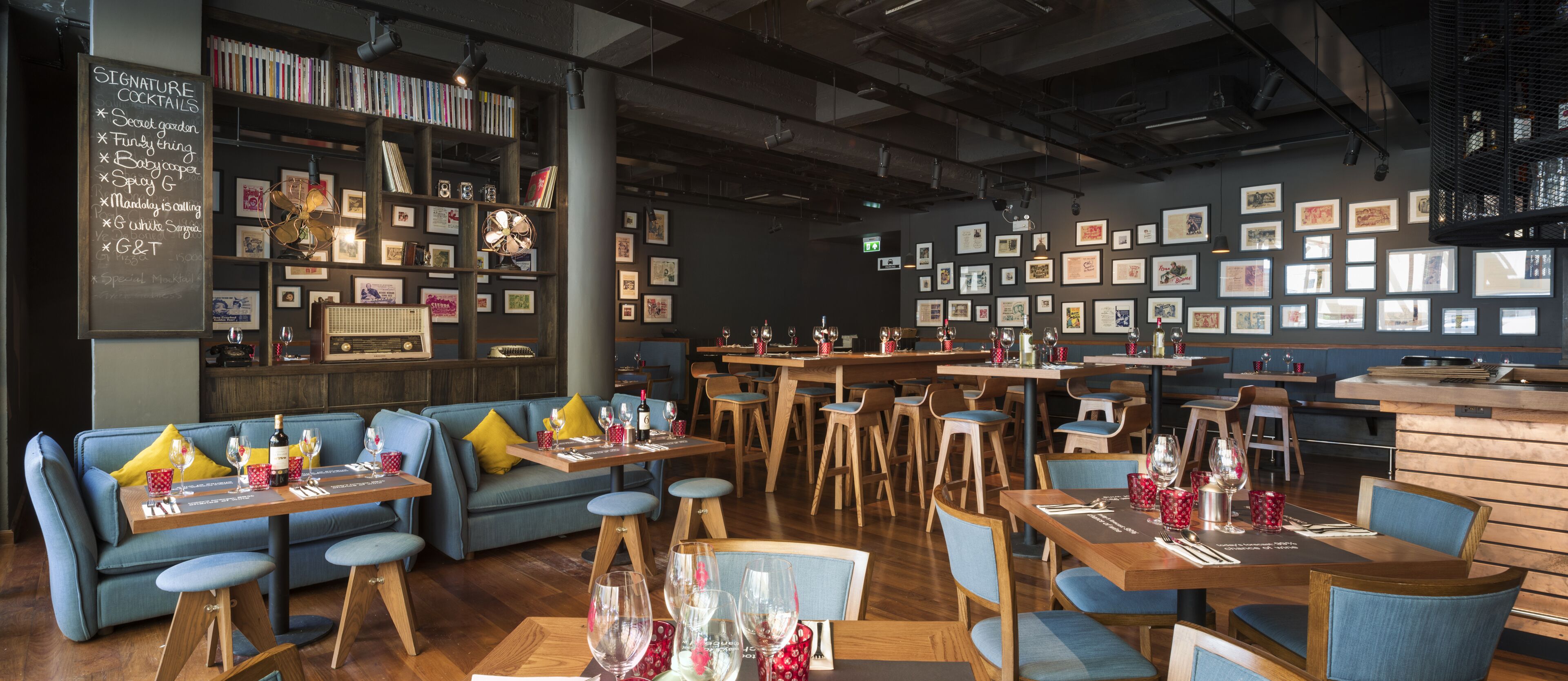 A cozy restaurant with wooden furniture, a chalkboard menu, and framed pictures on the walls.