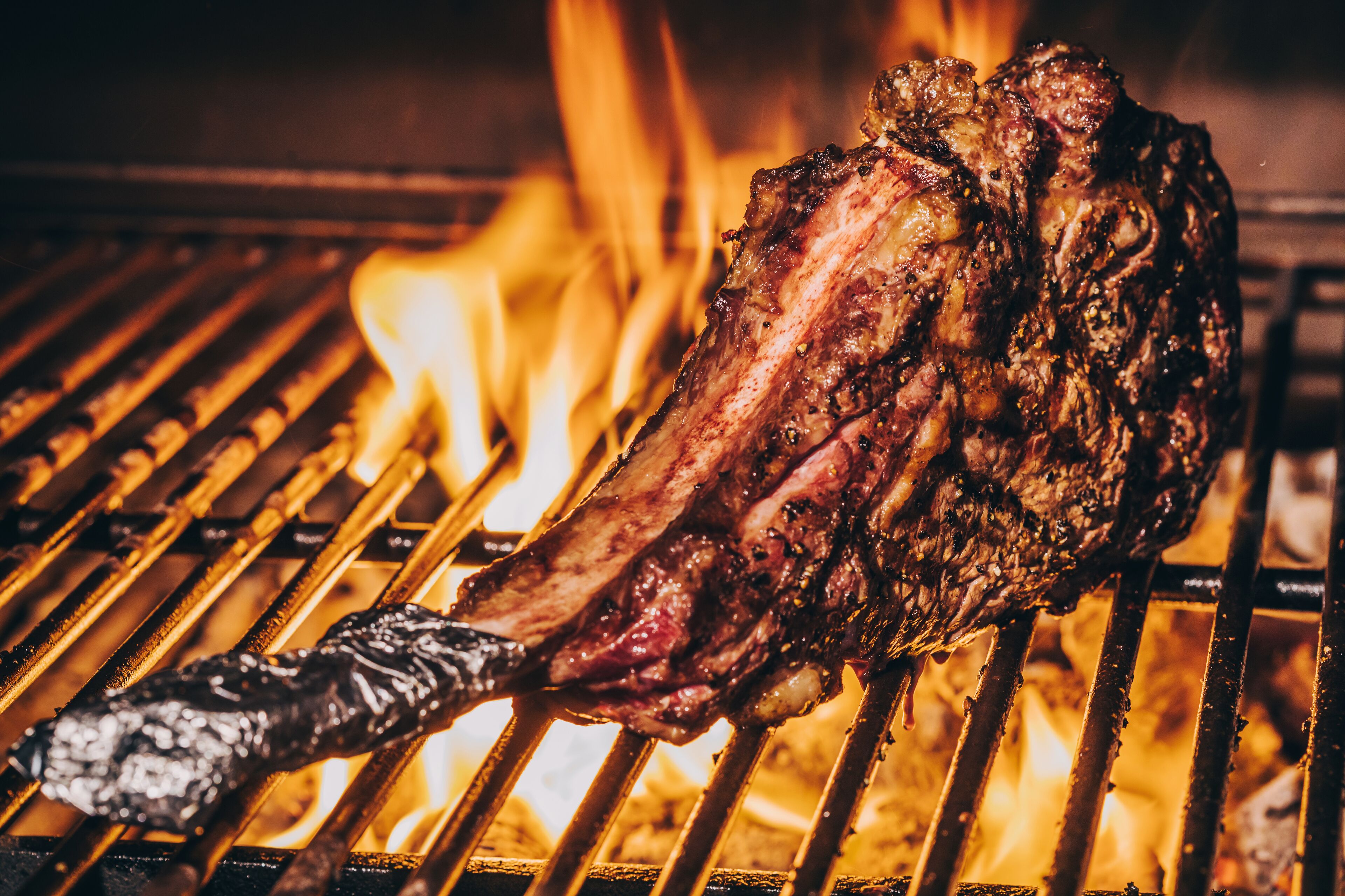 A steak being grilled over an open flame.