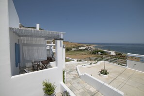 A modern white building with a terrace overlooking a coastal landscape. - Almyra Guesthouses (Skiros)