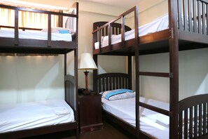 A bunk bed room with a nightstand and a lamp.