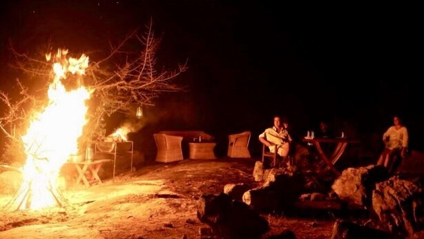 A campfire with people around it at night. - Thisara Guest Hotel Rooms (Kataragama)