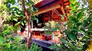 A wooden structure with a thatched roof, surrounded by lush greenery. - D'uma Residence (Denpasar)