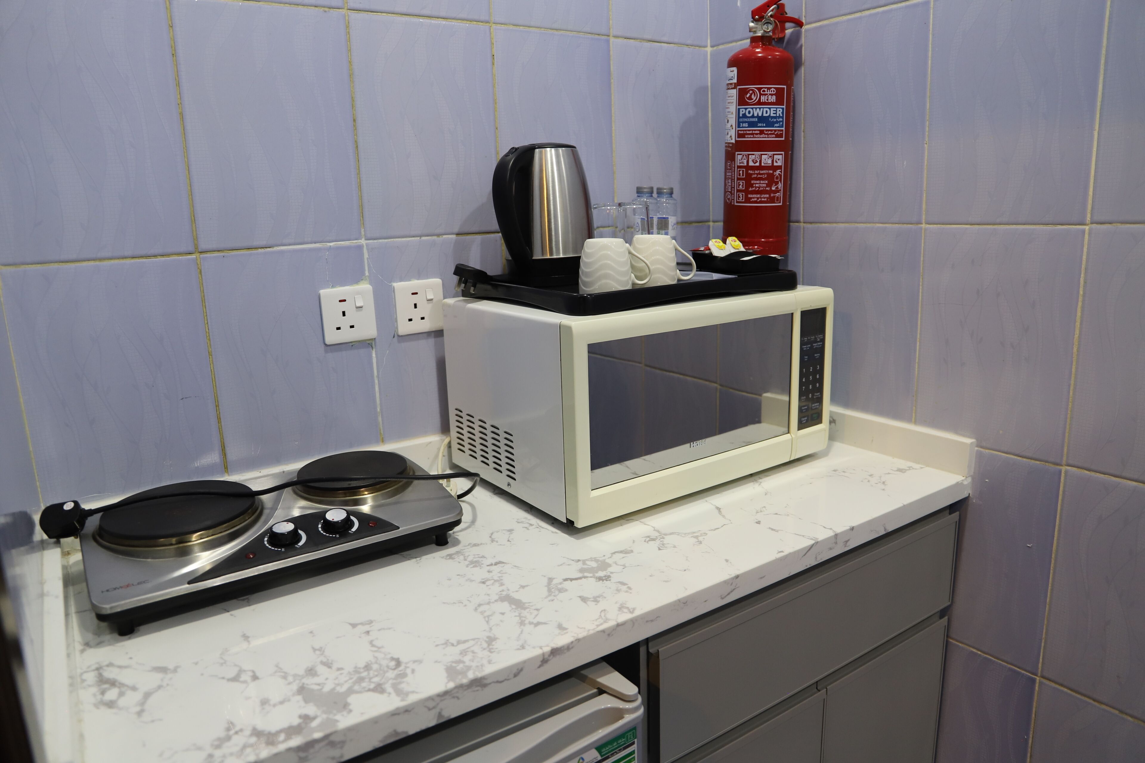 Una cuineta amb microones, bullidor elèctric i fogó de gas.