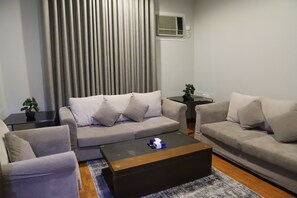 Ein modernes Wohnzimmer mit zwei Sofas, einem Couchtisch und einem kleinen Beistelltisch mit Pflanze.