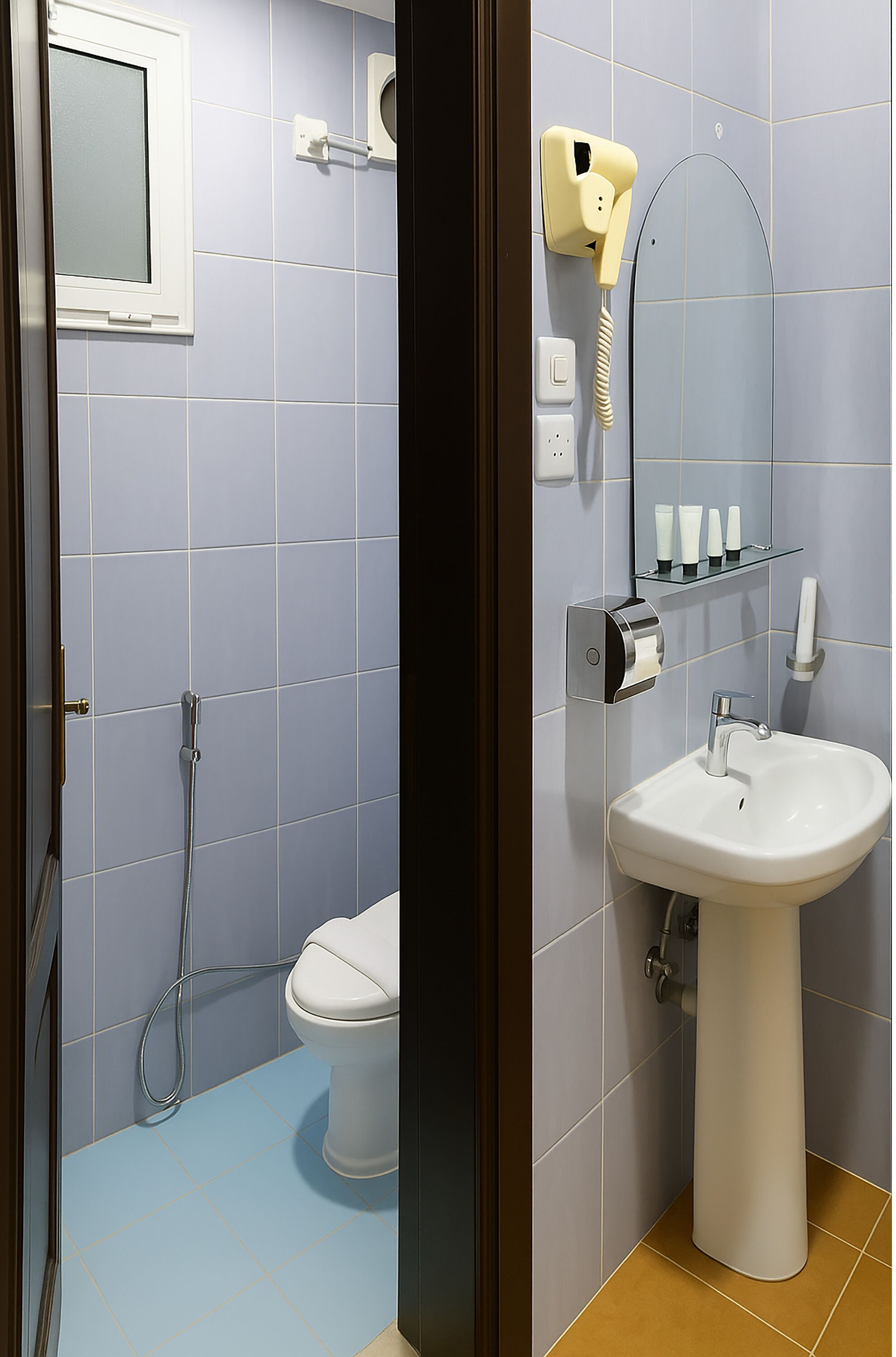 A bathroom with a toilet, sink, and shower.