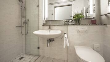 A bathroom with a shower, sink, and toilet.