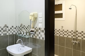 A bathroom with a sink, mirror, hairdryer, and shower. - Binayat Saraya Serviced Apartments (Tabuk)