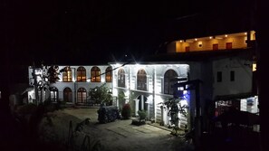 Um edifício com janelas em arco e um pátio.