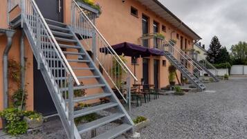 A building with multiple staircases leading to a covered outdoor seating area.
