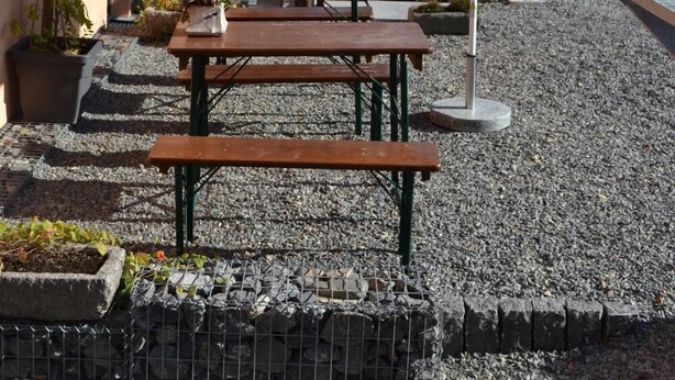 A courtyard with a metal staircase, outdoor seating, and potted plants.