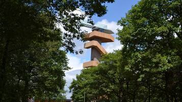 A modern building with a unique architectural design, surrounded by lush green trees.
