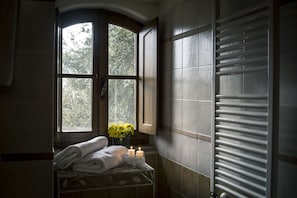 A bathroom with a window, a radiator, and towels on a shelf. - Croce di Bibbiano (Colle di Val d'Elsa)