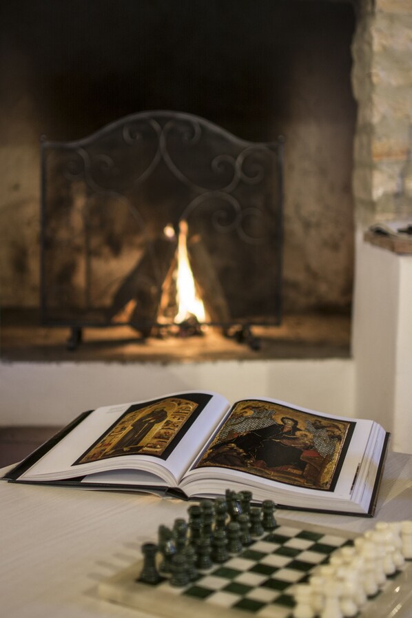An open book with a chessboard in front of a fireplace. - Croce di Bibbiano (Colle di Val d'Elsa)