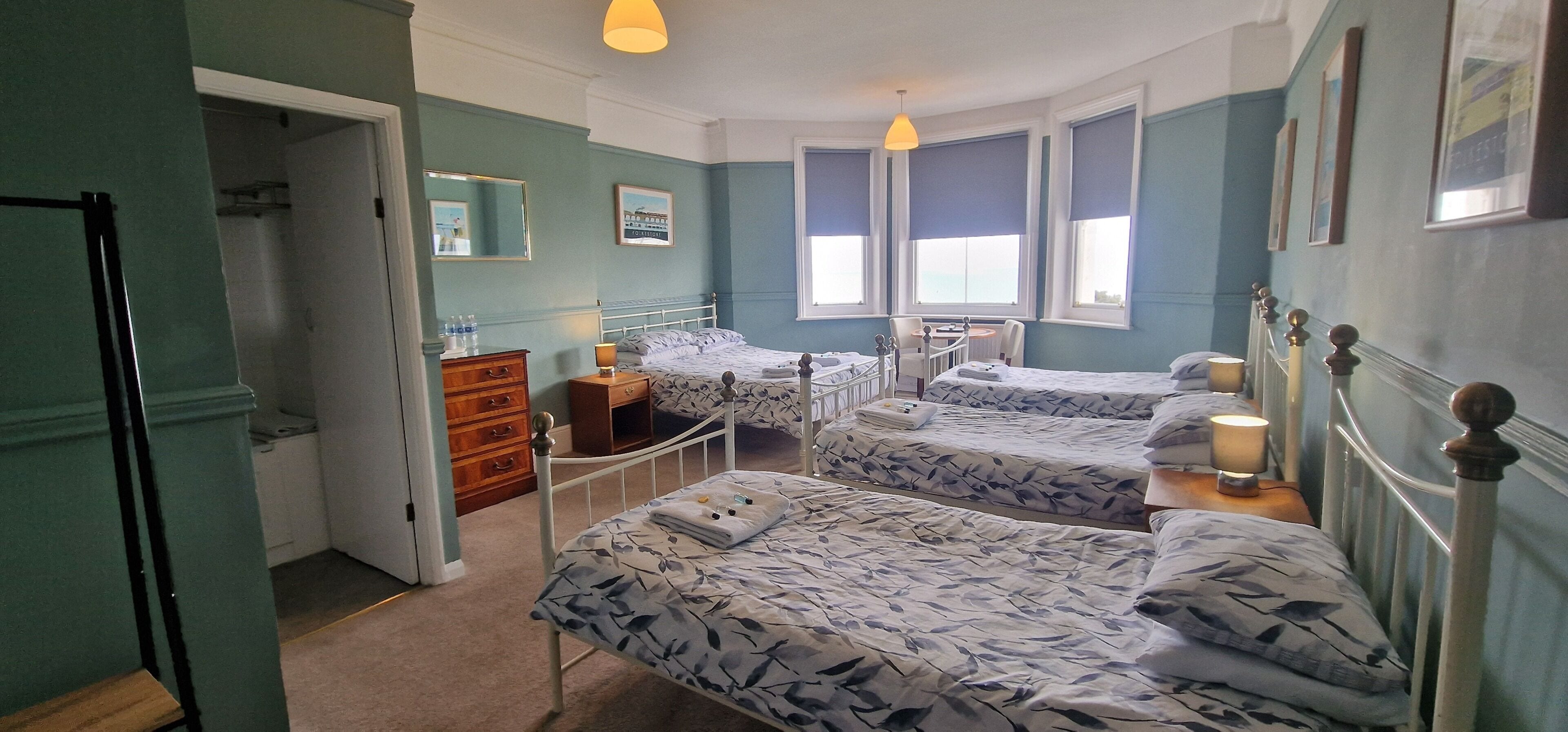 A bedroom with two beds, a dresser, a chair, and a table.
