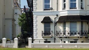 A large, multi-story building with a white facade, multiple windows, and a black metal staircase. - Westward Ho Hotel (Folkestone)