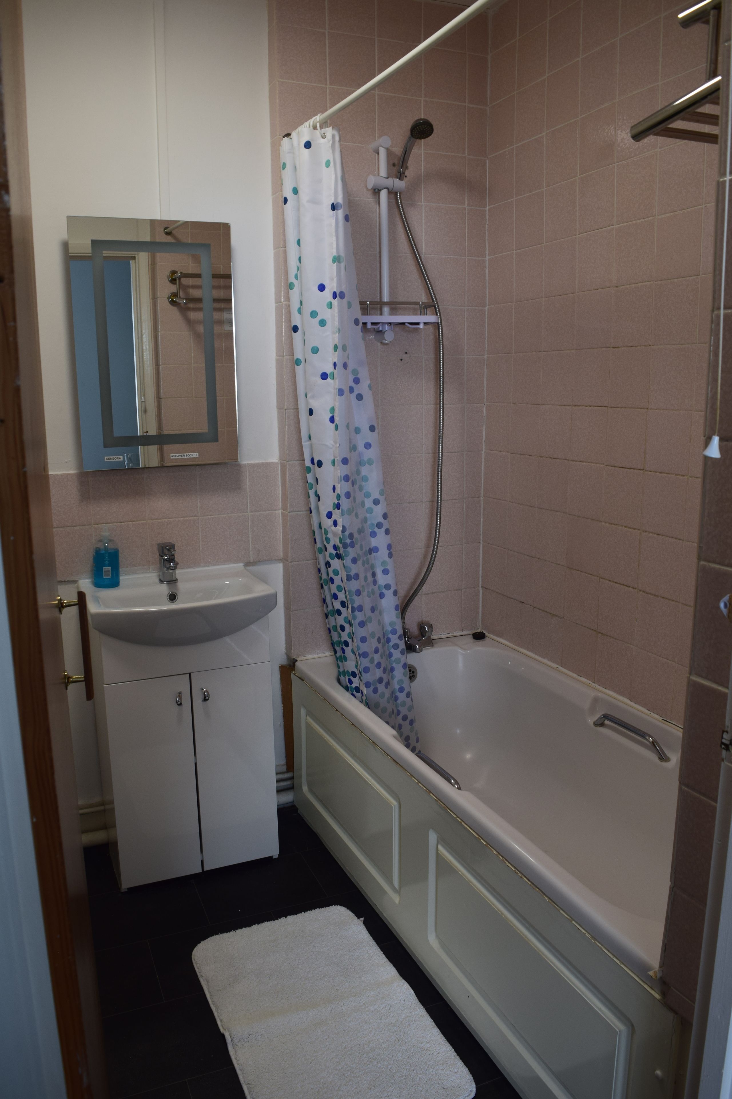 Ein Badezimmer mit Waschbecken, Spiegel, Dusche und Badewanne.