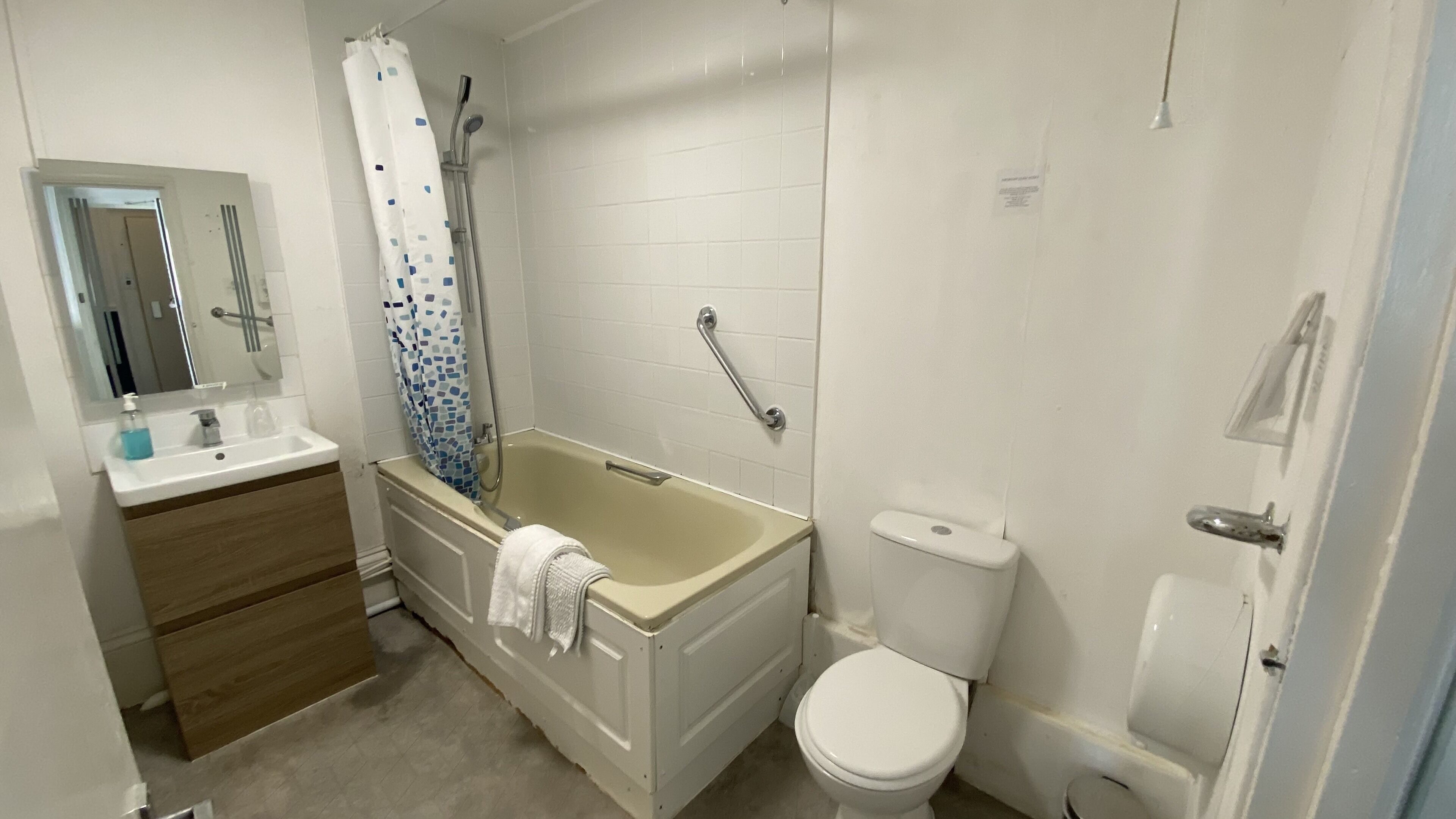 A bathroom with a bathtub, toilet, and sink.