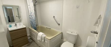 A bathroom with a bathtub, toilet, and sink.
