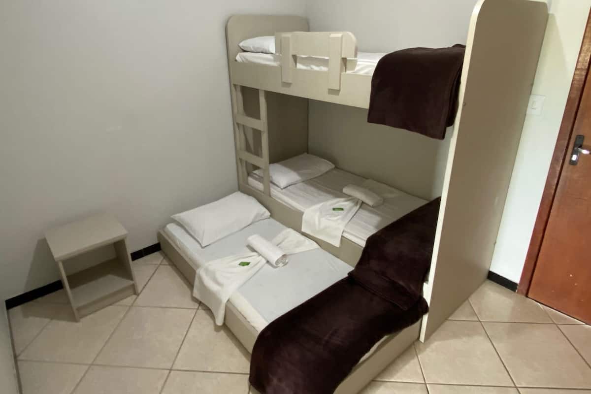A bunk bed room with a small shelf and a door.