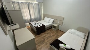 A hotel room with a bed, a desk, and a TV. - Hotel Panorâmico (Penha)