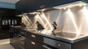 Una cocina moderna con electrodomésticos de acero inoxidable, horno empotrado y extractor.