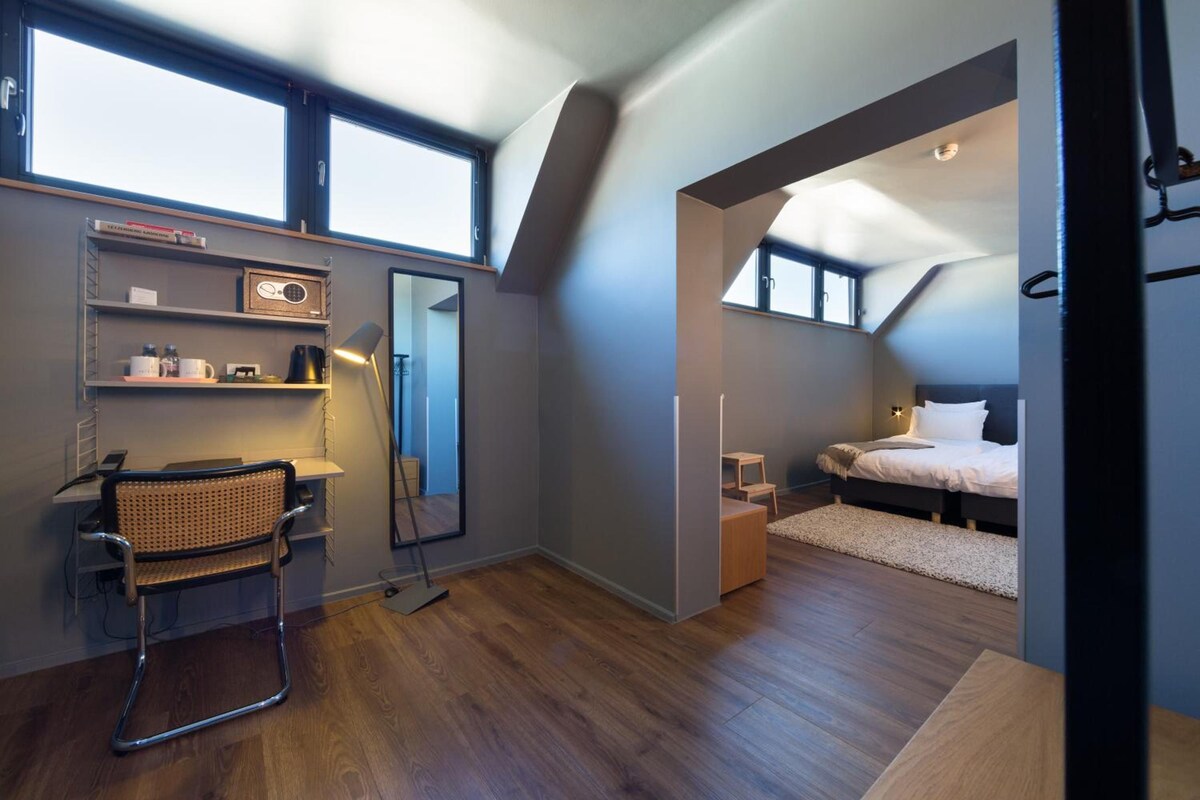 Un dormitorio moderno con escritorio, silla y cama.