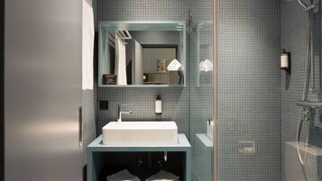 Un bagno moderno con un lavabo rettangolare, una cabina doccia in vetro e uno specchio sopra il lavabo.