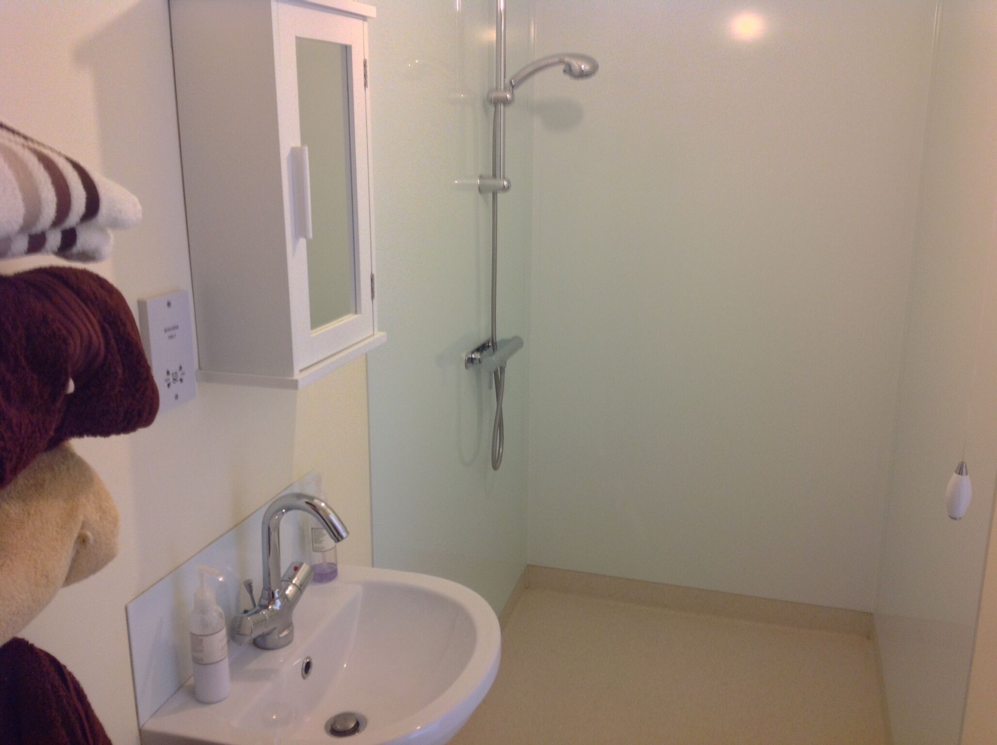 Un baño con lavamanos, espejo y ducha.