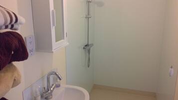 Un baño con lavamanos, espejo y ducha.