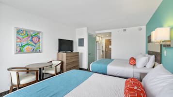 A hotel room with two beds, a desk, a chair, a television, and a colorful abstract painting on the wall.