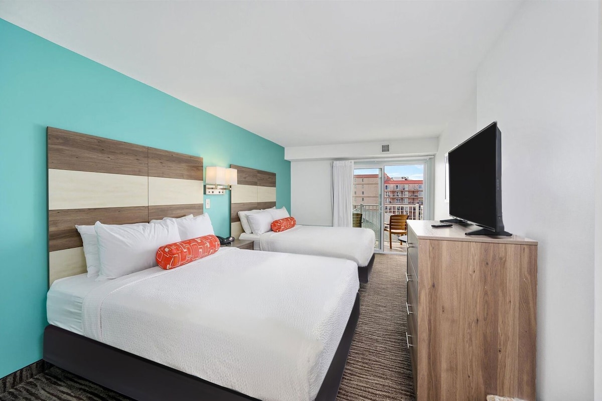 Une chambre d’hôtel avec deux lits, une télévision et une vue sur les immeubles.