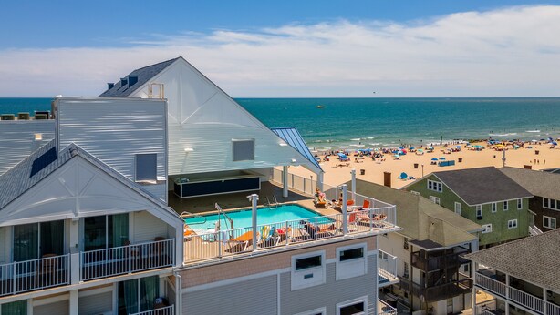 Un hôtel en bord de mer doté d’une piscine, offrant une vue sur la plage et comprenant plusieurs balcons.