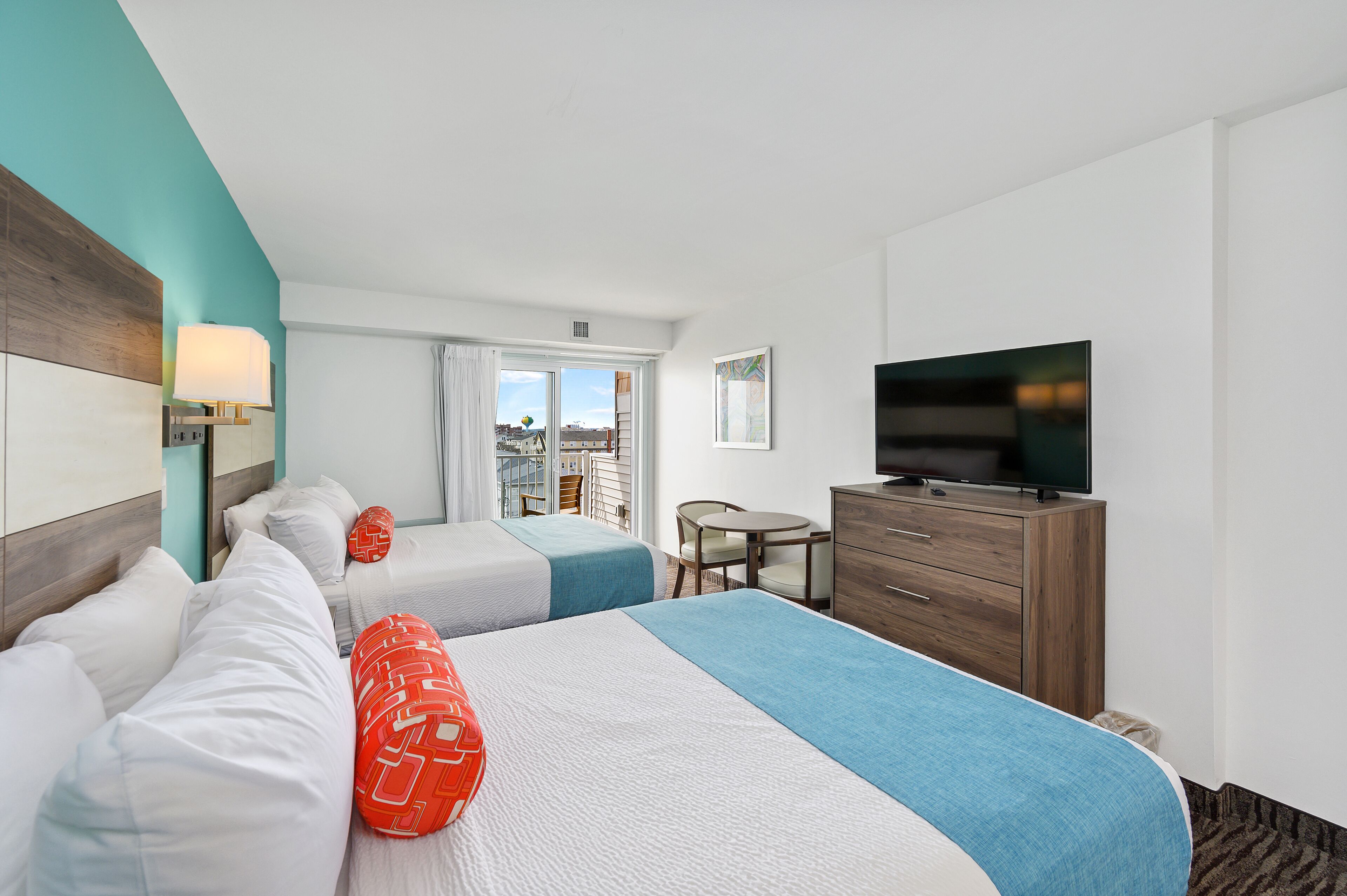 Une chambre d’hôtel avec deux lits, une télévision, un bureau et une vue sur la ville.
