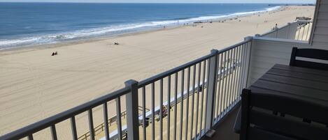 A balcony with a view of a beach and ocean.