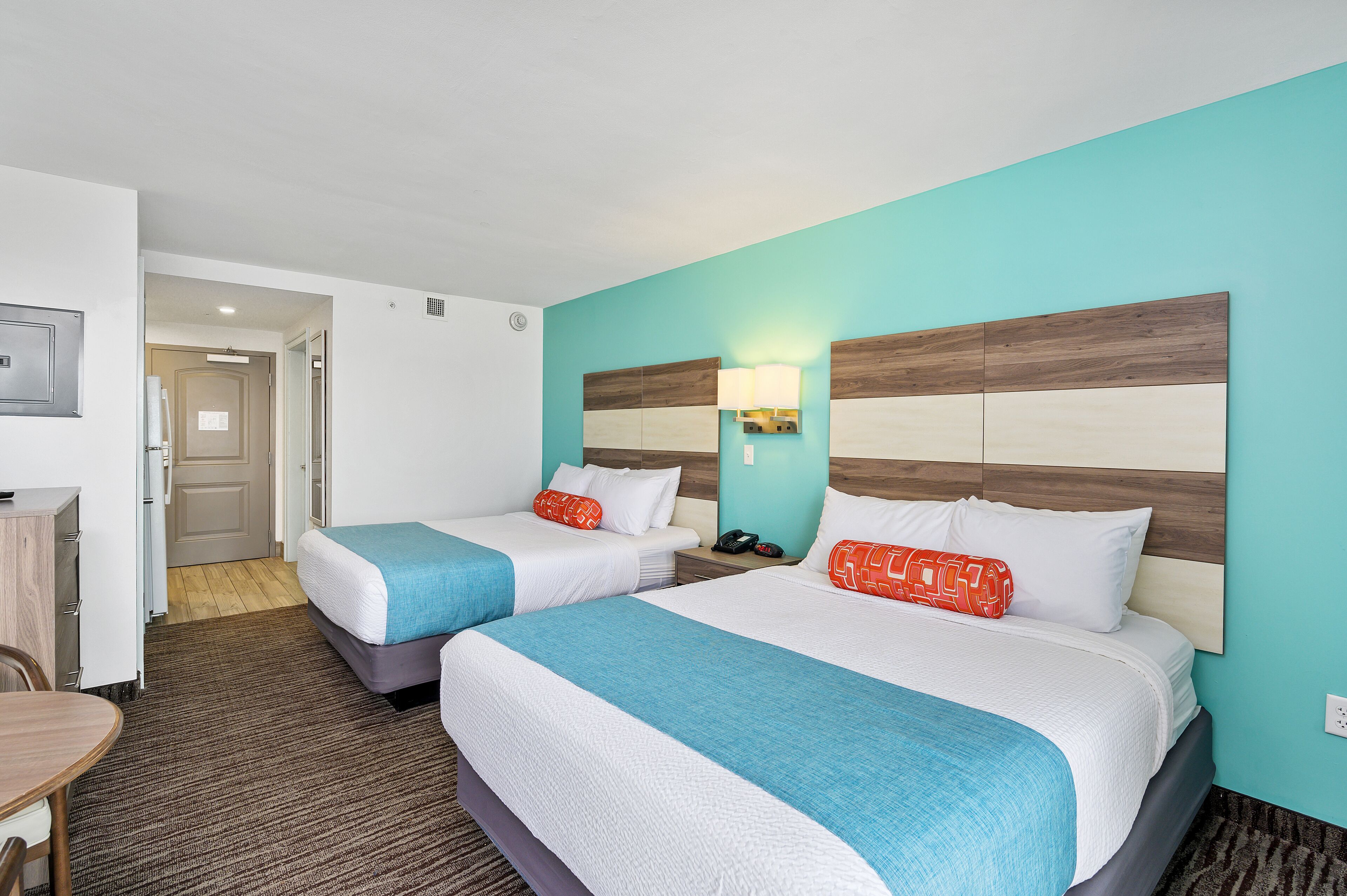 Une chambre d’hôtel avec deux lits, un bureau et une chaise.