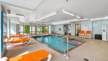 Une piscine intérieure dotée de plusieurs couloirs de nage, de chaises longues et d’un vestiaire.