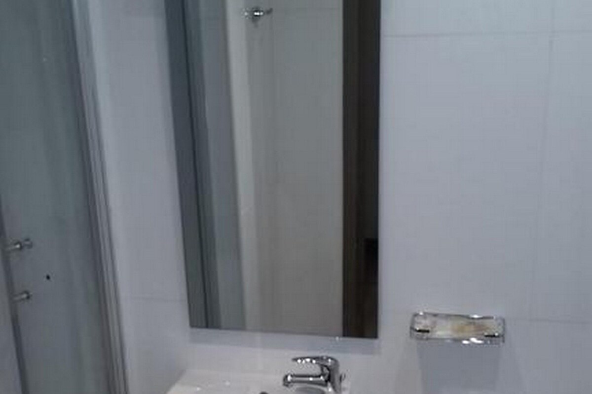 A bathroom with a glass shower enclosure, a sink, and a toilet.
