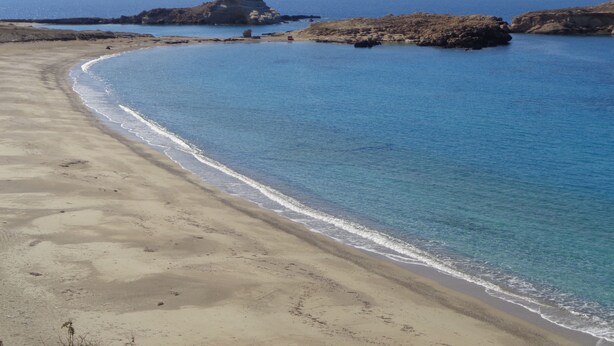 A beach with clear blue waters, sandy shore, and rocky outcrops. - Blue and White Studios & Apartments (Karpathos)