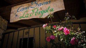 A wooden sign with the text "Casa Baina La Pergola" hanging above a wrought iron railing. - Apartments Casa Saina (Rovinj)