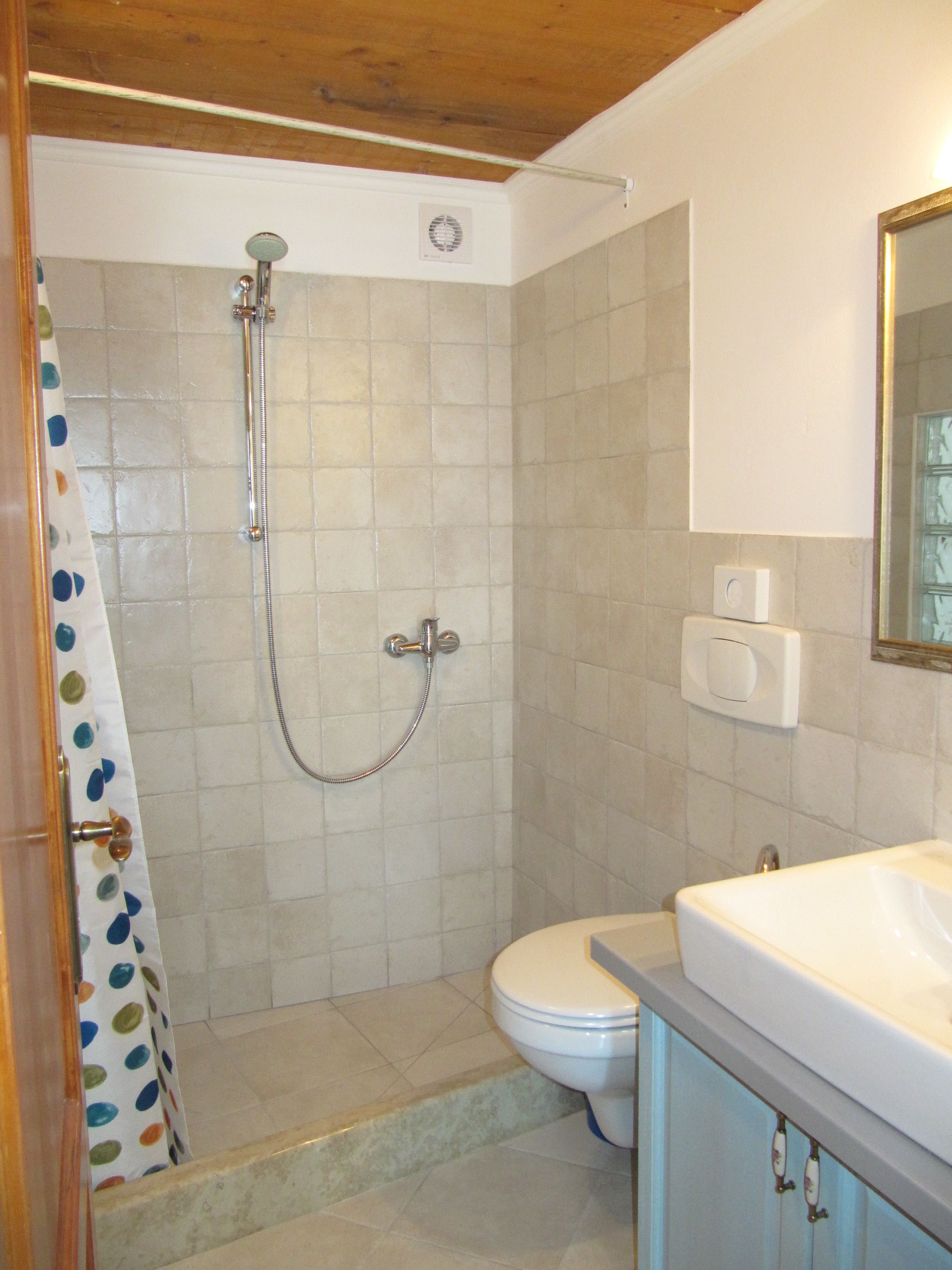 A bathroom with a shower, toilet, and sink.
