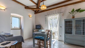 A dining area with a table, chairs, and a television. - Apartments Casa Saina (Rovinj)