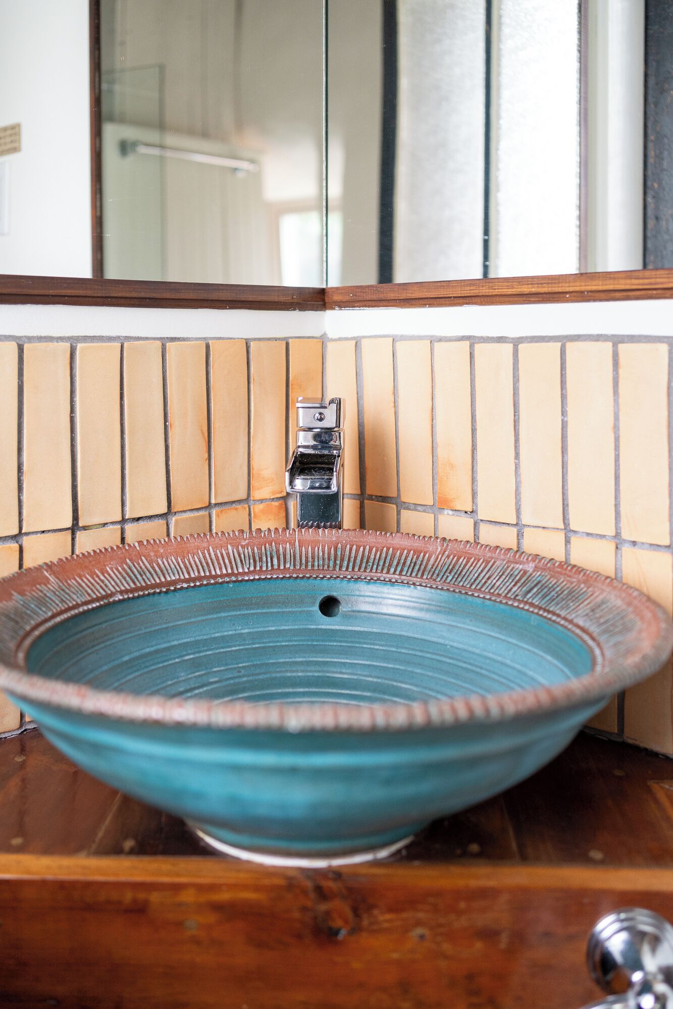 Un baño con un lavamanos grande, redondo y de cerámica turquesa.